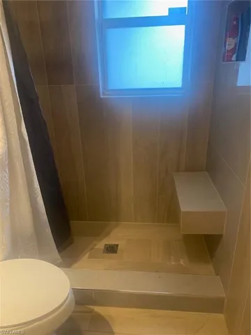Bathroom featuring a shower with shower curtain and tile patterned flooring