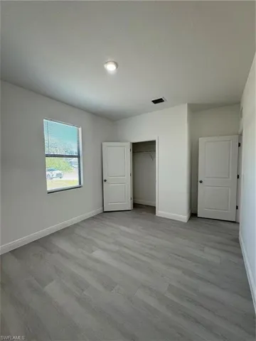 Unfurnished bedroom with light wood finished floors, a textured ceiling, and a closet
