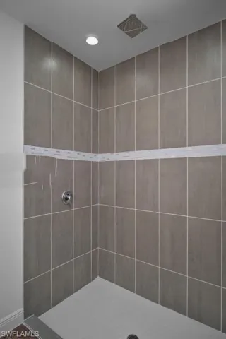 Full bath featuring tiled shower and recessed lighting