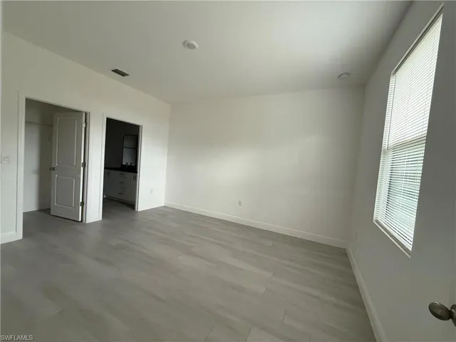 Unfurnished bedroom with light wood-type flooring and ensuite bath