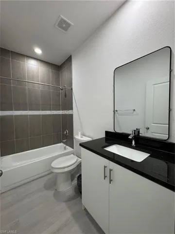 Full bathroom with vanity, bathtub / shower combination, and recessed lighting
