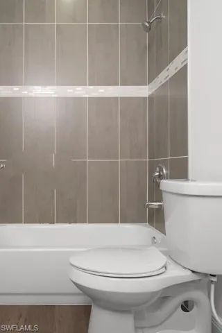 Full bath with shower / tub combination and wood finished floors