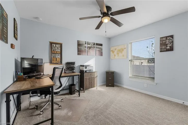 Home office featuring ceiling fan and light colored carpet