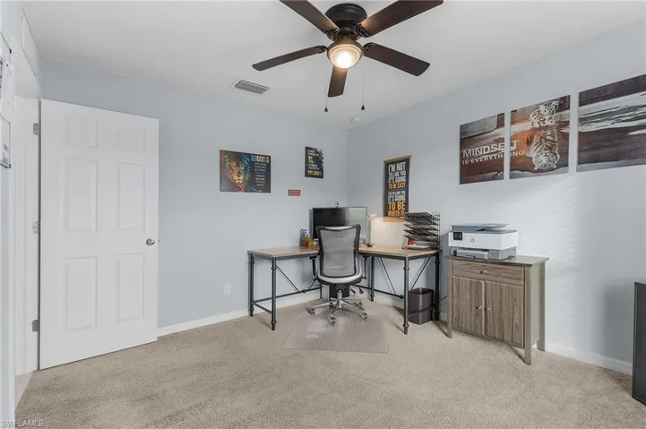 Office space with light carpet and ceiling fan