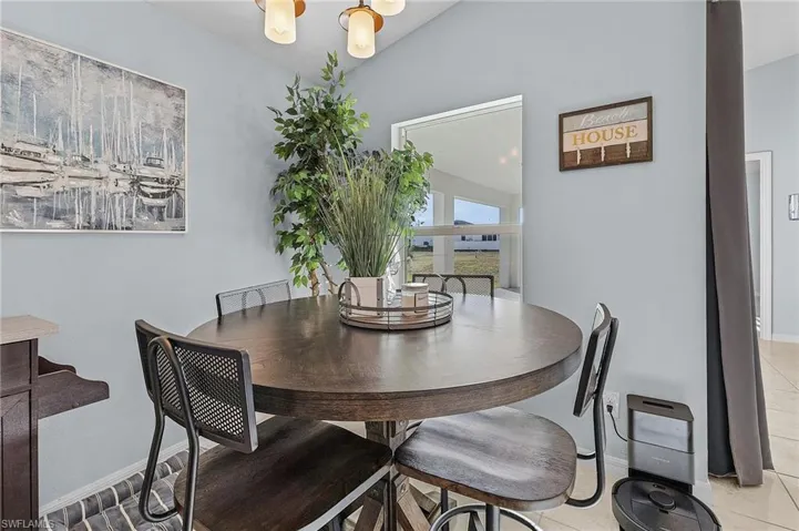 Dining space with light tile patterned flooring and lofted ceiling