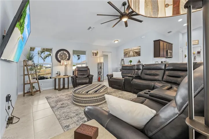 Tiled living room with vaulted ceiling and ceiling fan