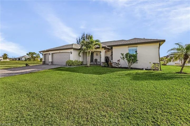 Ranch-style house featuring a garage and a front yard