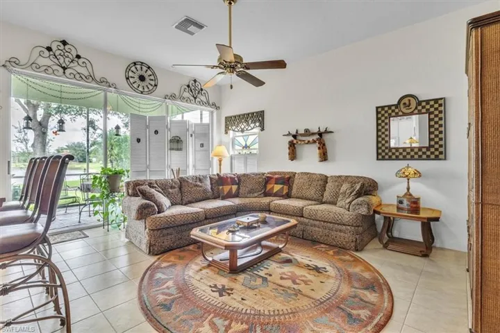 Living area featuring tile patterned floors and a ceiling fan