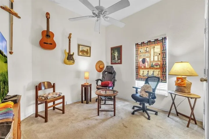 Sitting room with carpet and a ceiling fan