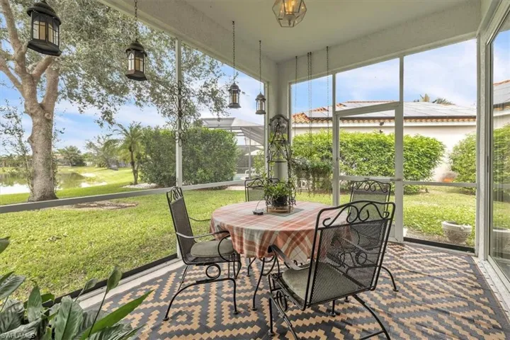 Sunroom featuring a water view and outdoor dining area