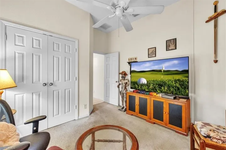 Carpeted living room featuring ceiling fan