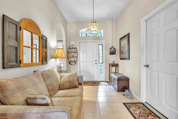 Entryway featuring light tile patterned floors and arched walkways
