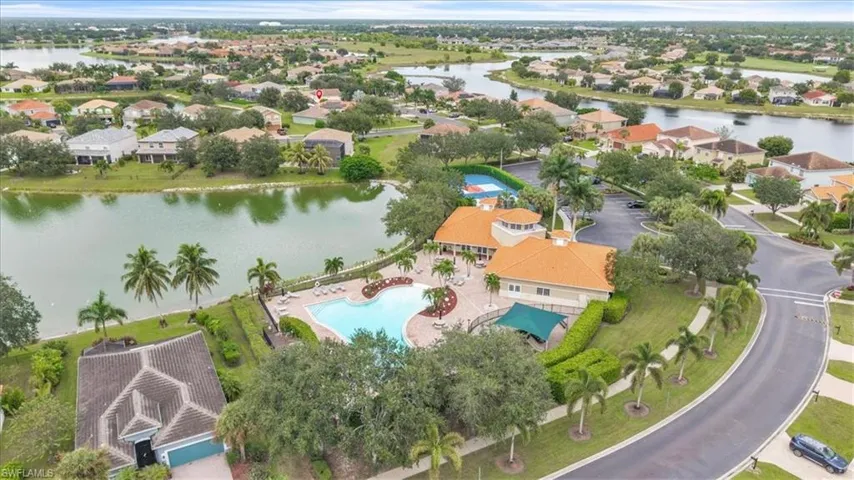 Aerial view of residential area with a large body of water and a pool area
