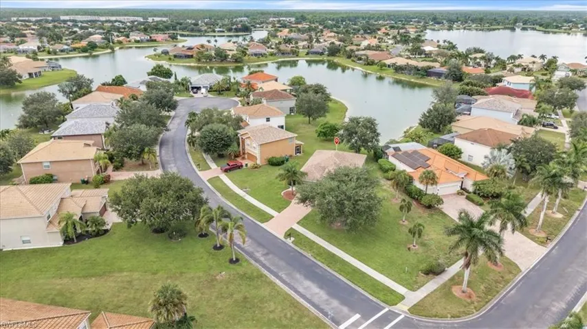 Aerial view of property and surrounding area featuring a nearby body of water and nearby suburban area