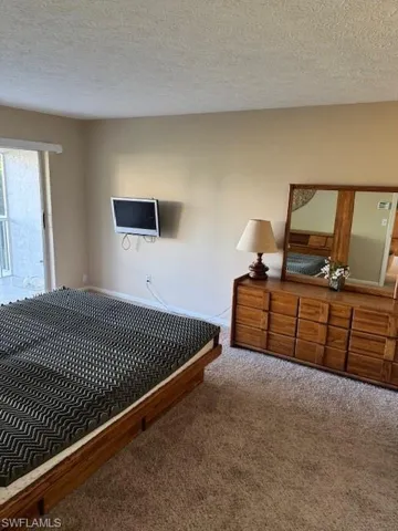 Bedroom featuring carpet floors and a textured ceiling
