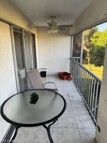 Balcony featuring a sunroom, a ceiling fan, and outdoor dining area