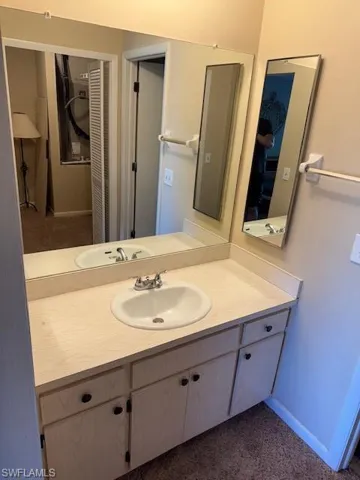 Bathroom featuring dark carpet and vanity