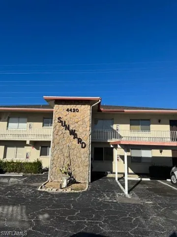 View of building exterior featuring uncovered parking