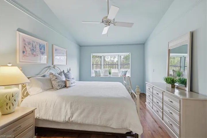 Bedroom featuring vaulted ceiling, dark wood-style floors, and ceiling fan