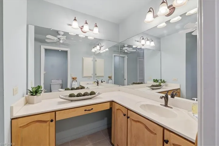 Full bathroom with a ceiling fan, vanity, and light tile patterned flooring