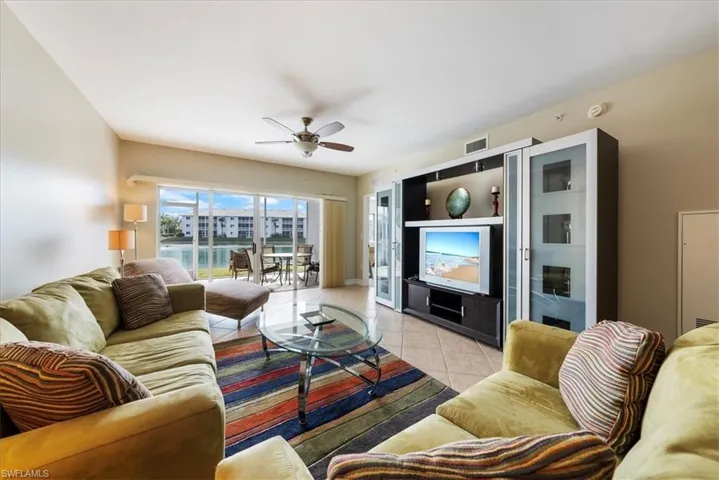 Living room featuring light tile patterned flooring and ceiling fan