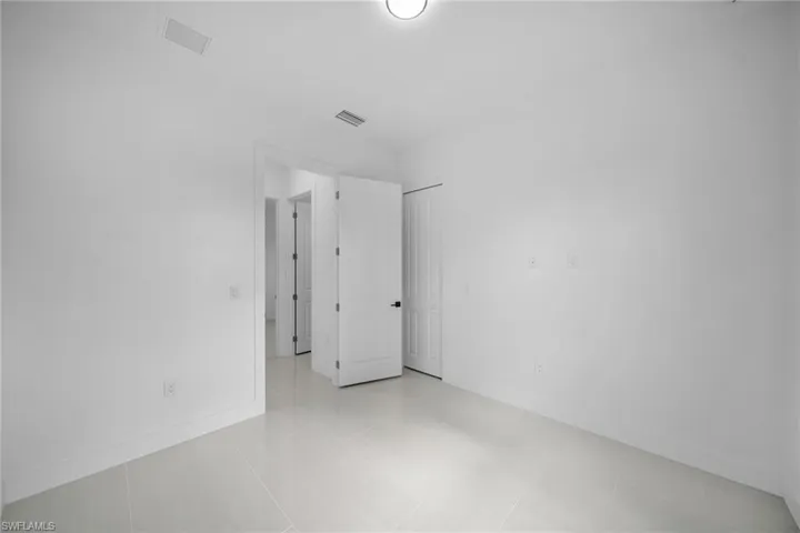 Unfurnished room featuring light tile patterned flooring and baseboards