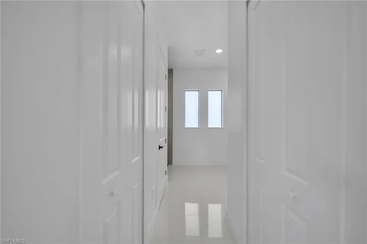 Hallway with recessed lighting and light tile patterned flooring