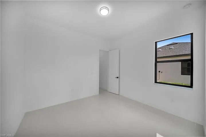 Empty room with tile patterned floors and baseboards