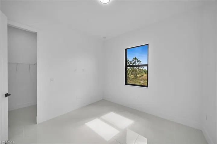 Unfurnished bedroom with a spacious closet and baseboards
