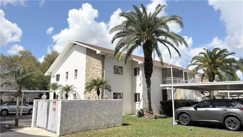 View of home's exterior featuring stucco siding, covered parking, and a lawn