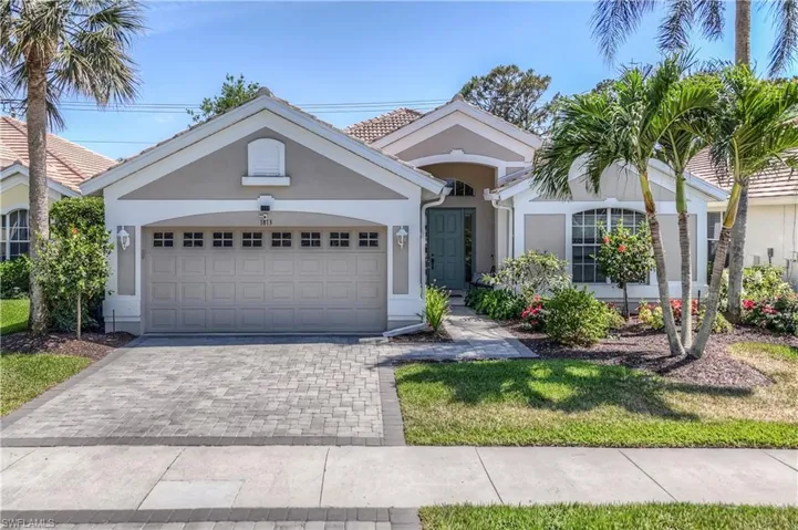 View of front of house with decorative driveway, stucco siding, a tiled roof, and a garage