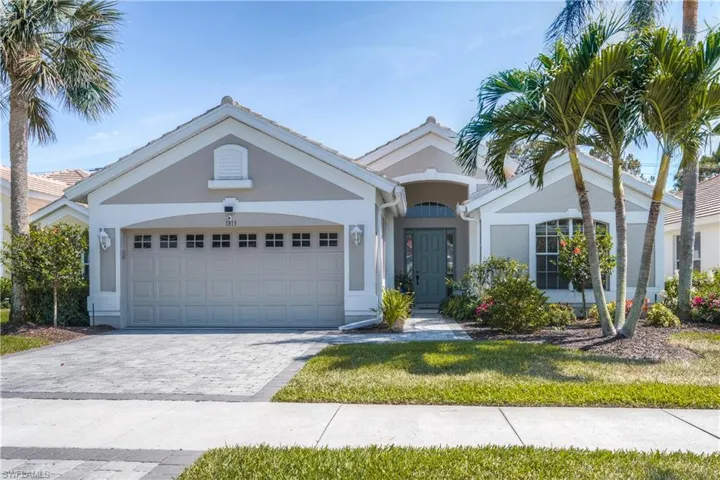 View of front facade featuring stucco siding, new paver decorative driveway, front yard and 2 car garage