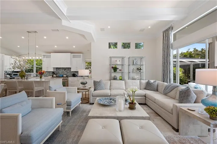 Living room featuring beam ceiling, recessed lighting, and ornamental molding
