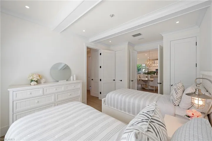 Bedroom featuring beam ceiling, a chandelier, crown molding, visible vents, and wood finished floors