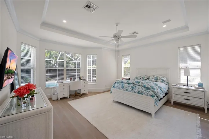 Main Bedroom with multiple windows, a view of the pool and a tray ceiling