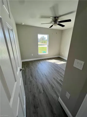 Spare room featuring dark hardwood / wood-style floors and ceiling fan