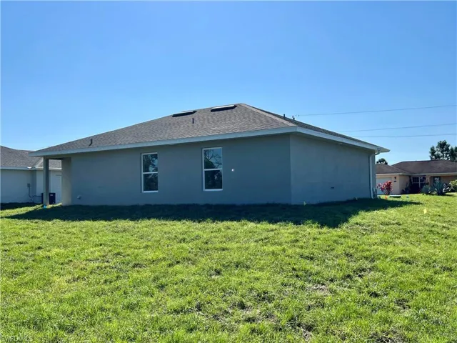 View of side of property featuring a lawn