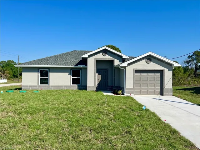 Ranch-style home featuring a garage and a front yard