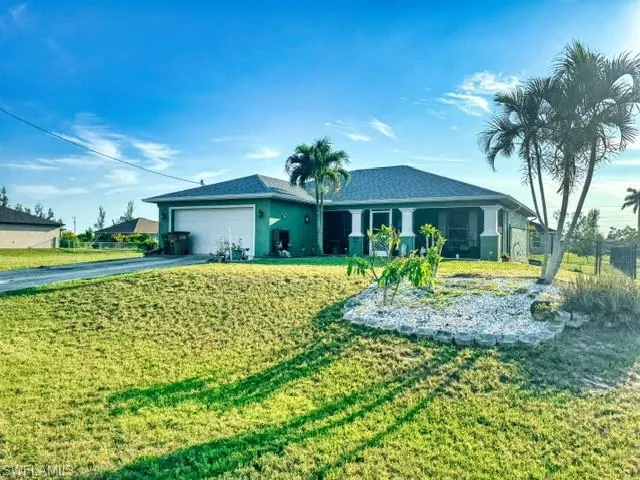 Ranch-style home featuring a garage and a front yard