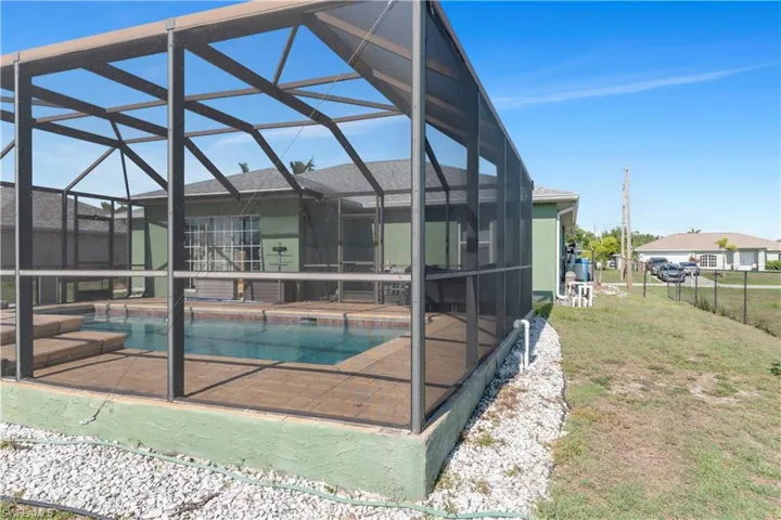 View of pool with  enclosure and a patio area