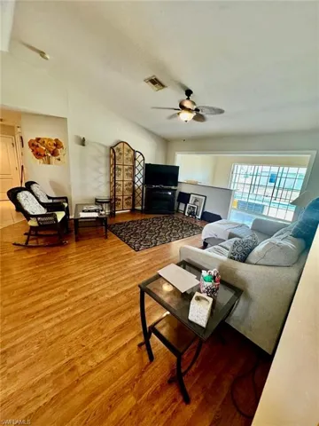 Living room with ceiling fan and wood-type flooring