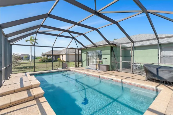View of pool with a patio and a lanai