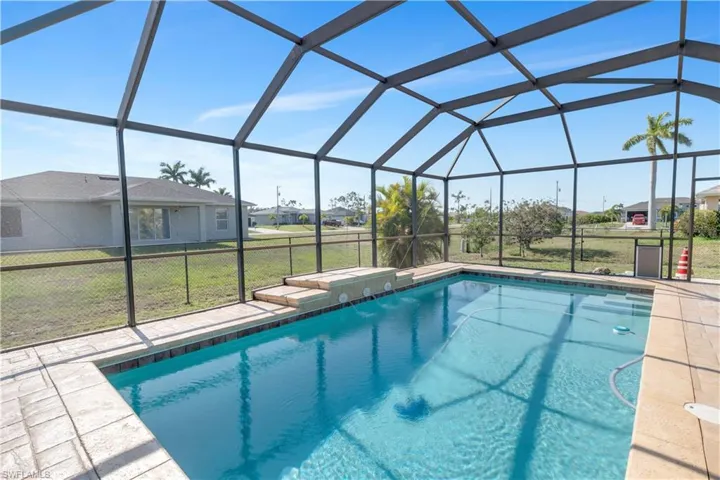 View of pool with a yard, enclosure, and a patio area