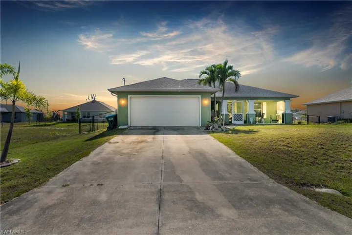 Ranch-style home with a garage and a lawn