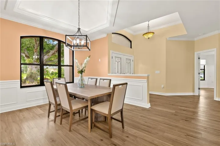 The Formal Dining Room has wainscoting and a Tray Ceiling with Crown Molding and LED Accent Lighting