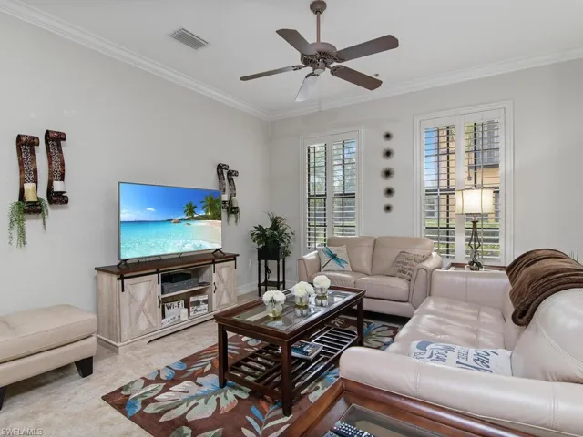 Living room with ornamental molding and a ceiling fan