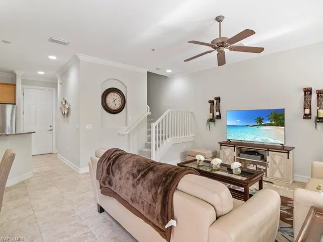 Living room featuring crown molding, ceiling fan, recessed lighting, stairway, and light tile patterned flooring