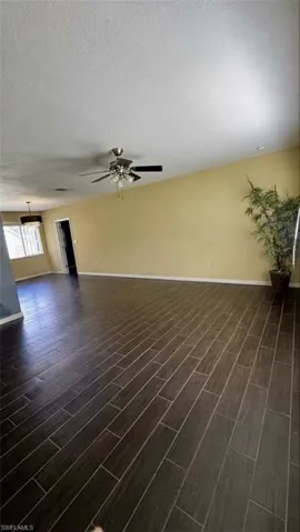 Open-concept room featuring wood-finish flooring, recessed lighting, and a multi-blade ceiling fan