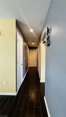 Hallway featuring wood-finish tile flooring, recessed lighting, and multi-panel interior doors
