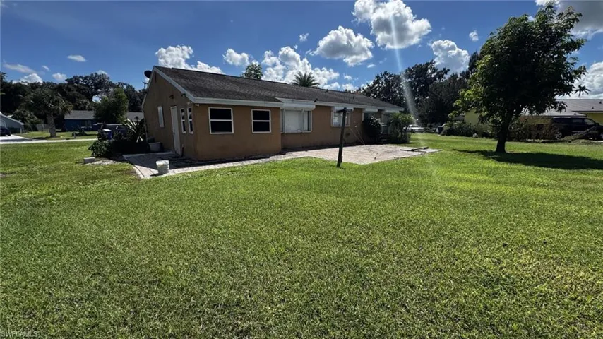 Stucco exterior, expansive open lawn, and rear paver patio